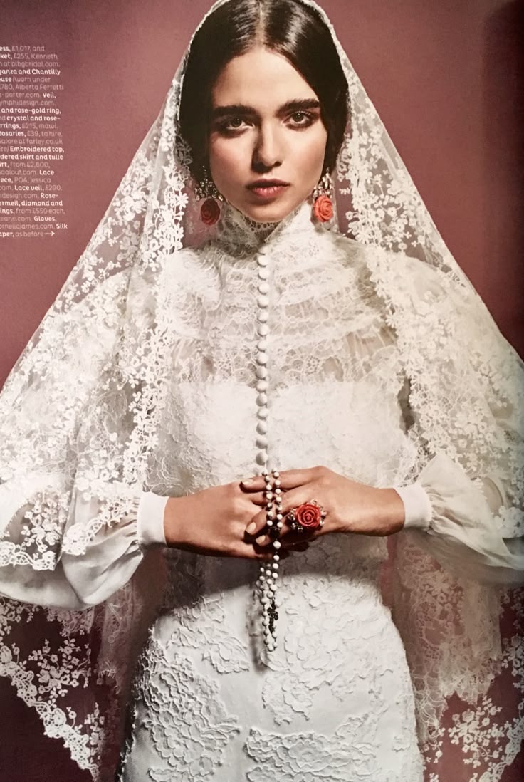 Bride in a high-neck lace dress and lace mantilla veil, holding a rosary