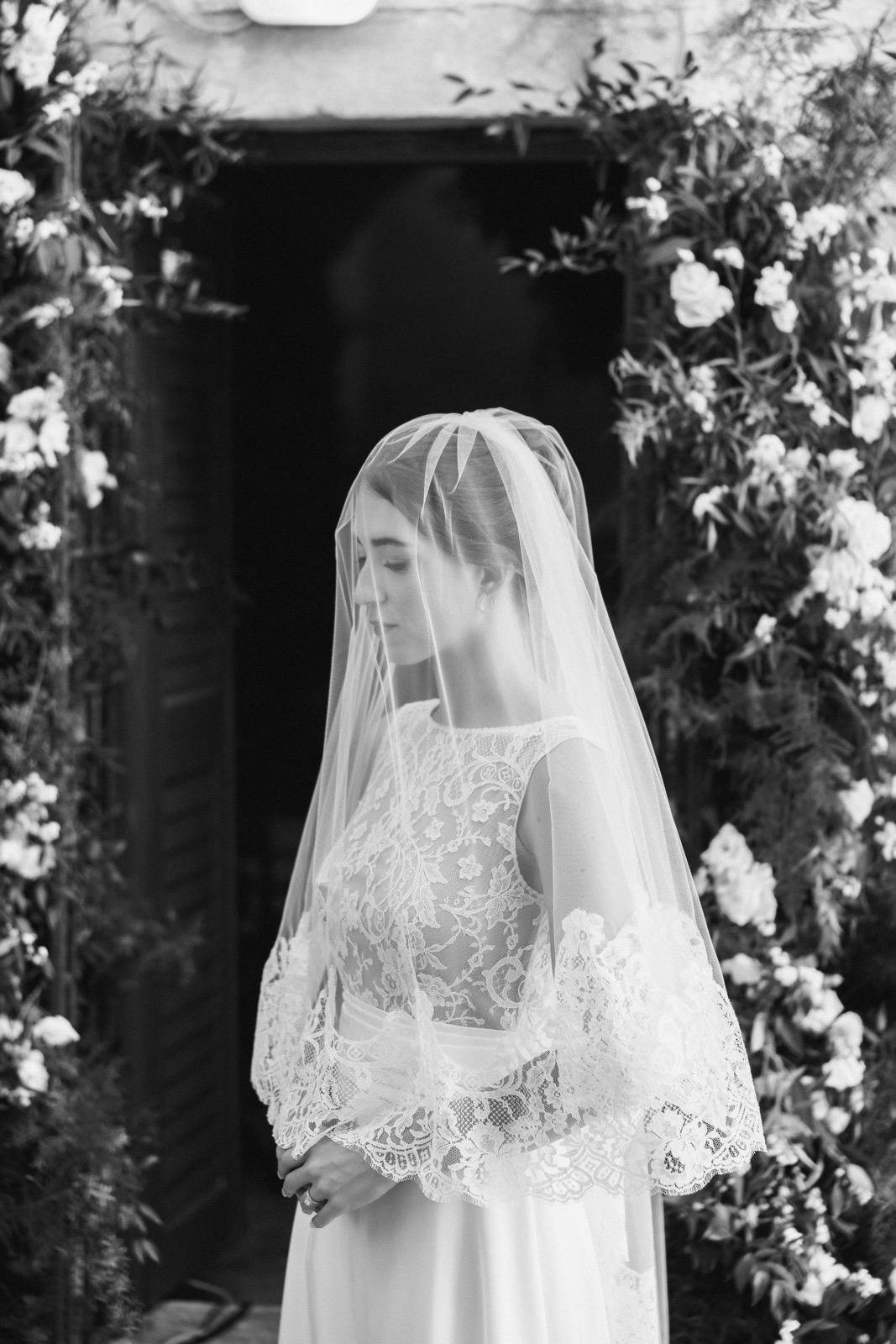 Bride wearing a French lace veil with a blusher over her face