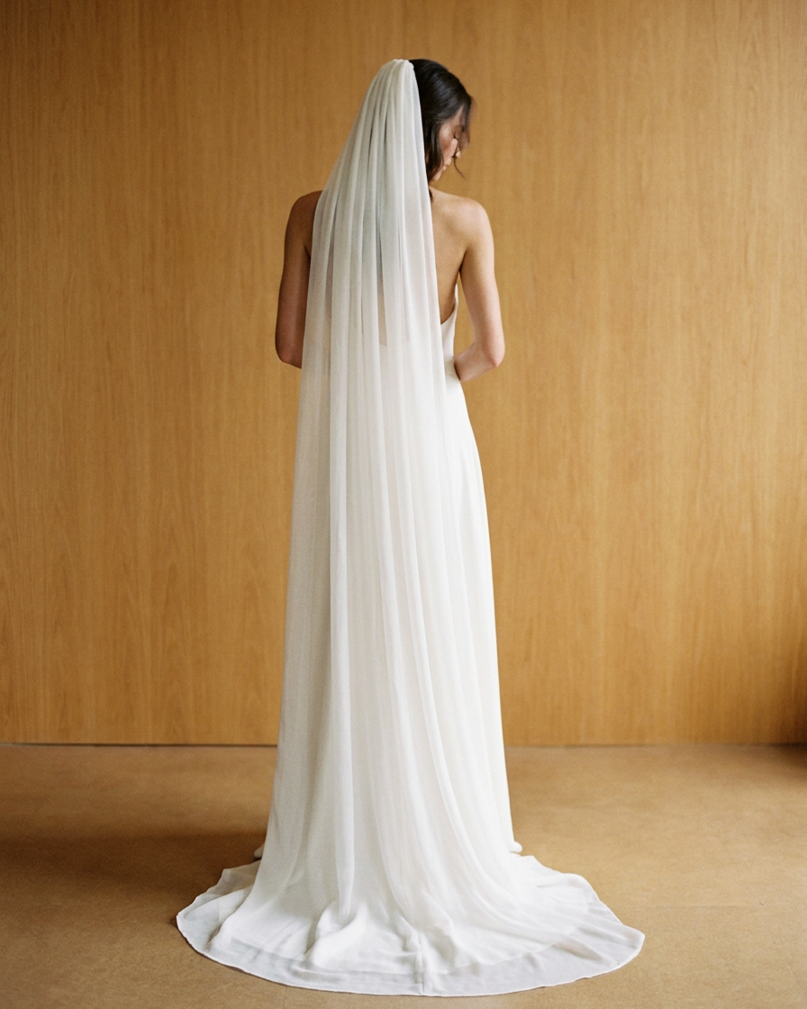 Full-length back view of the Aurore chapel-length silk chiffon veil pooling on the floor with a rounded edge