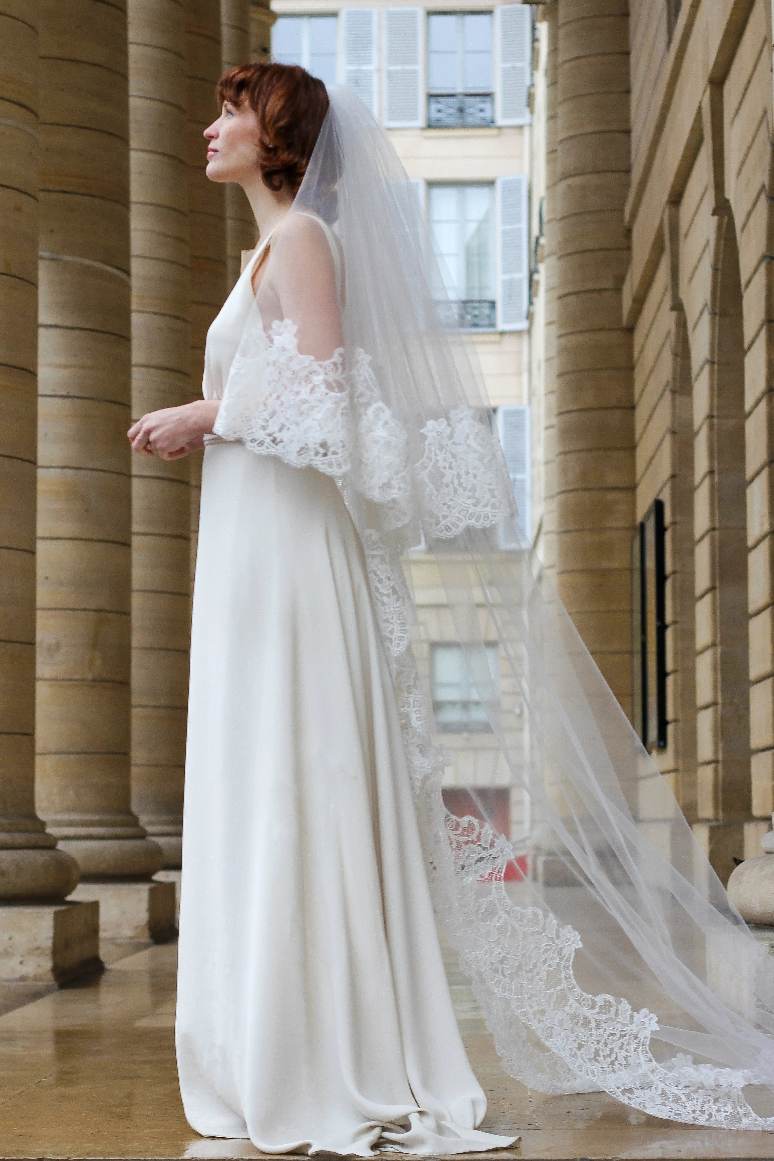 Young bride wearing an ivory cathedral bridal veil in fine tulle with elegant embroidery