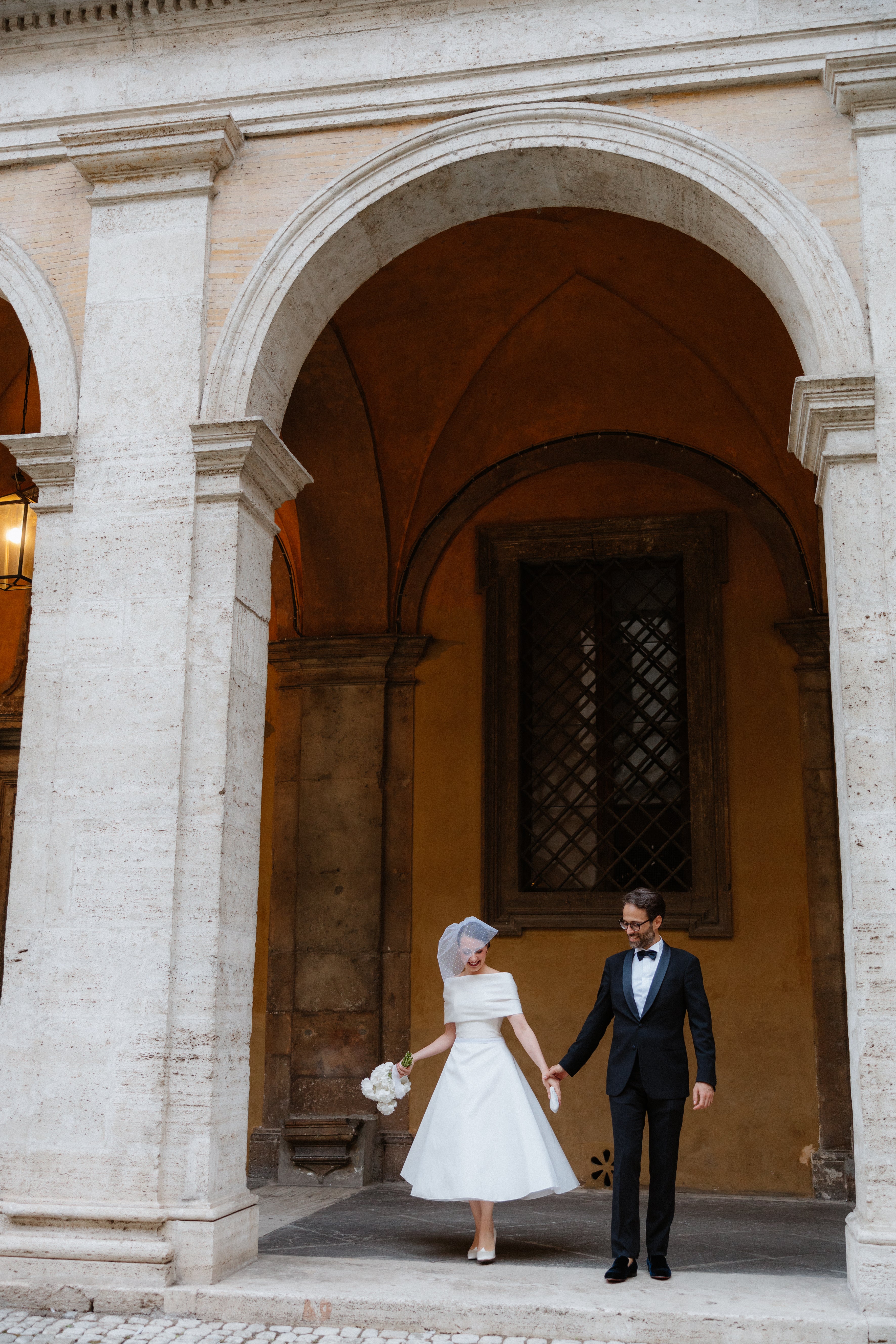 Bride wearing a classic birdcage veil and 1950s inspired dress on her wedding day