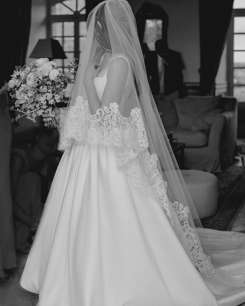 A bride with a lace cathedral wedding veil