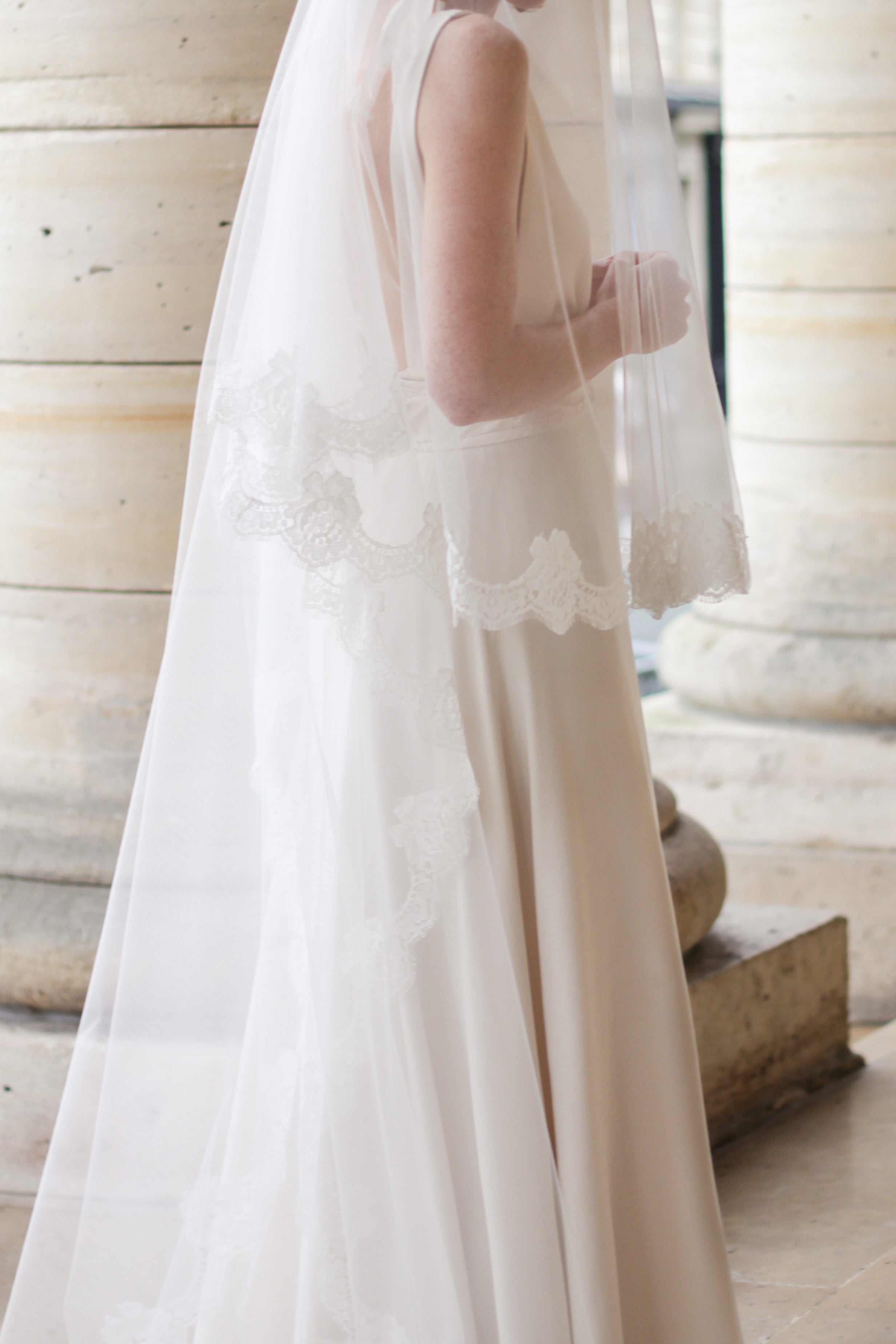 Delicate ivory lace veil paired with classic bridal gown