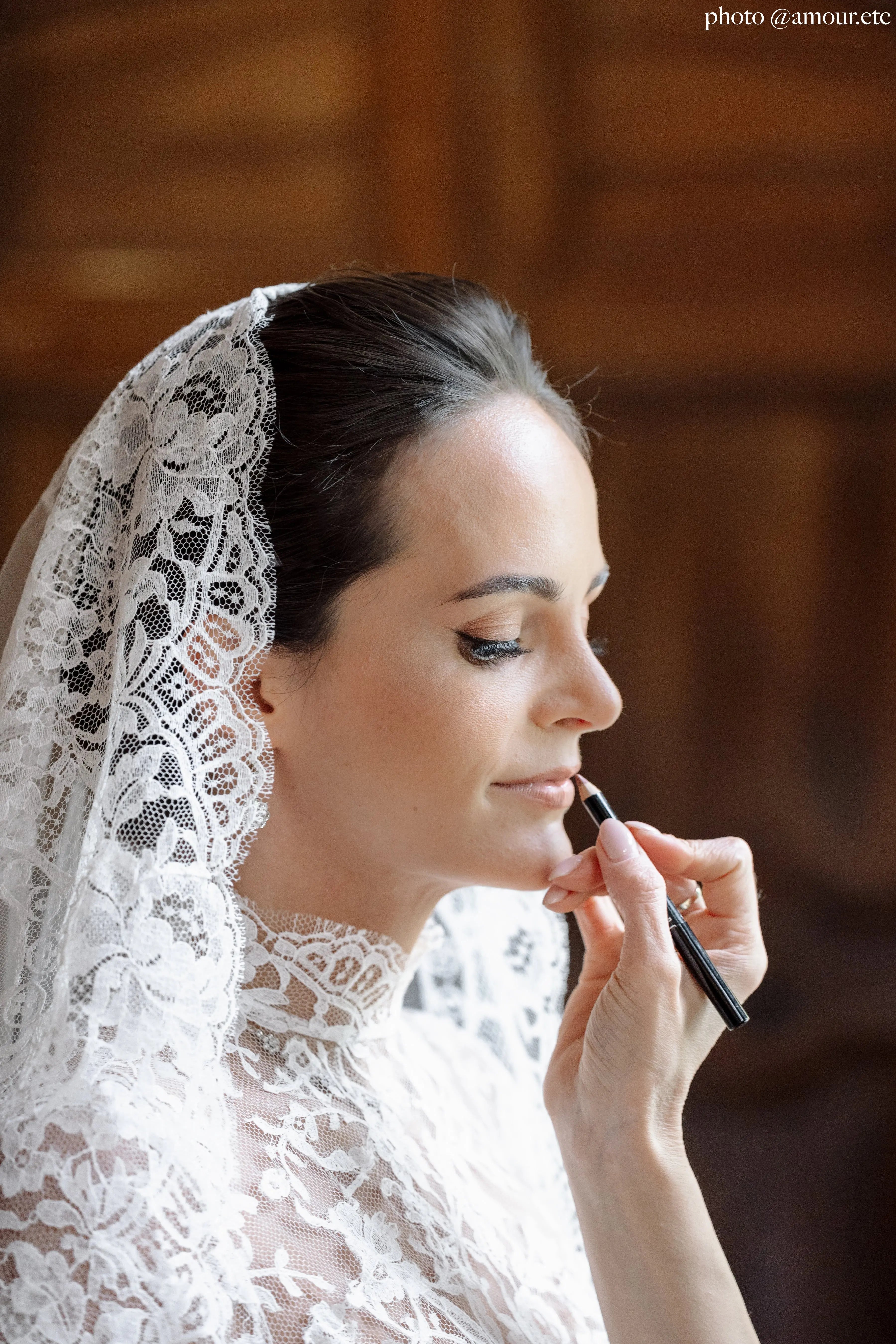 Bride wearing an ivory lace wedding veil in fine tulle with elegant lace edge, as a mantilla.