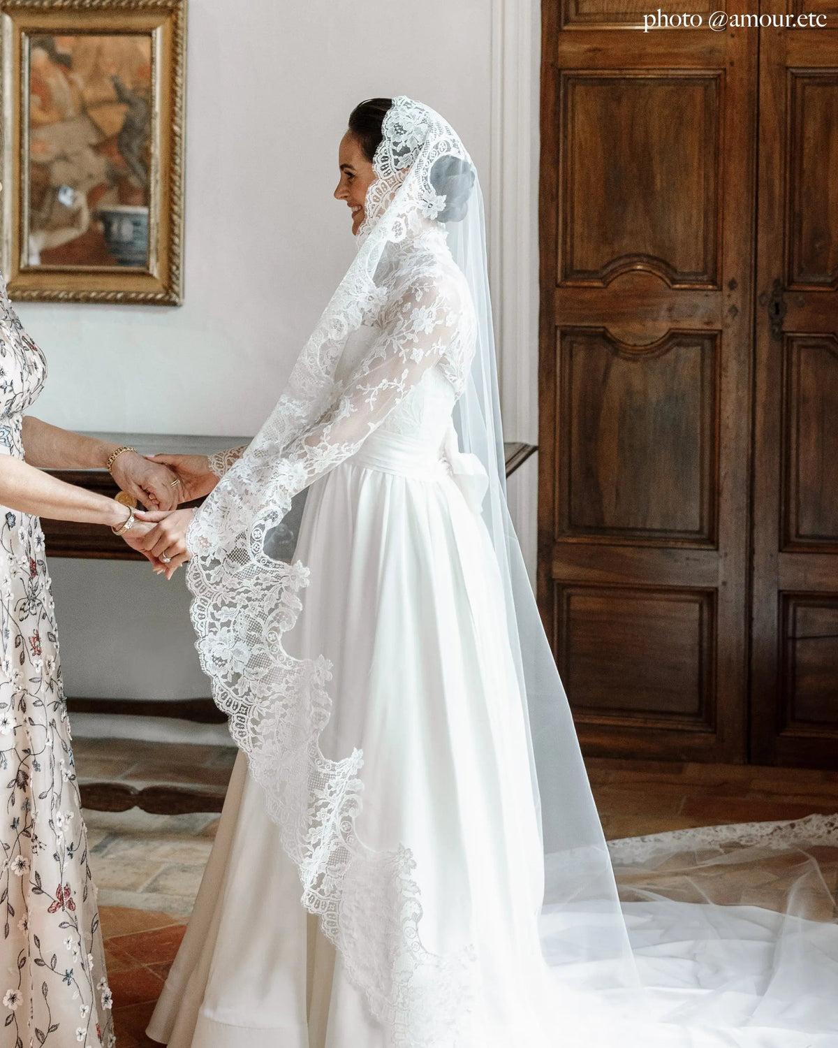 Side profile of a bride in the Avec Toi mantilla, the lace border framing her face