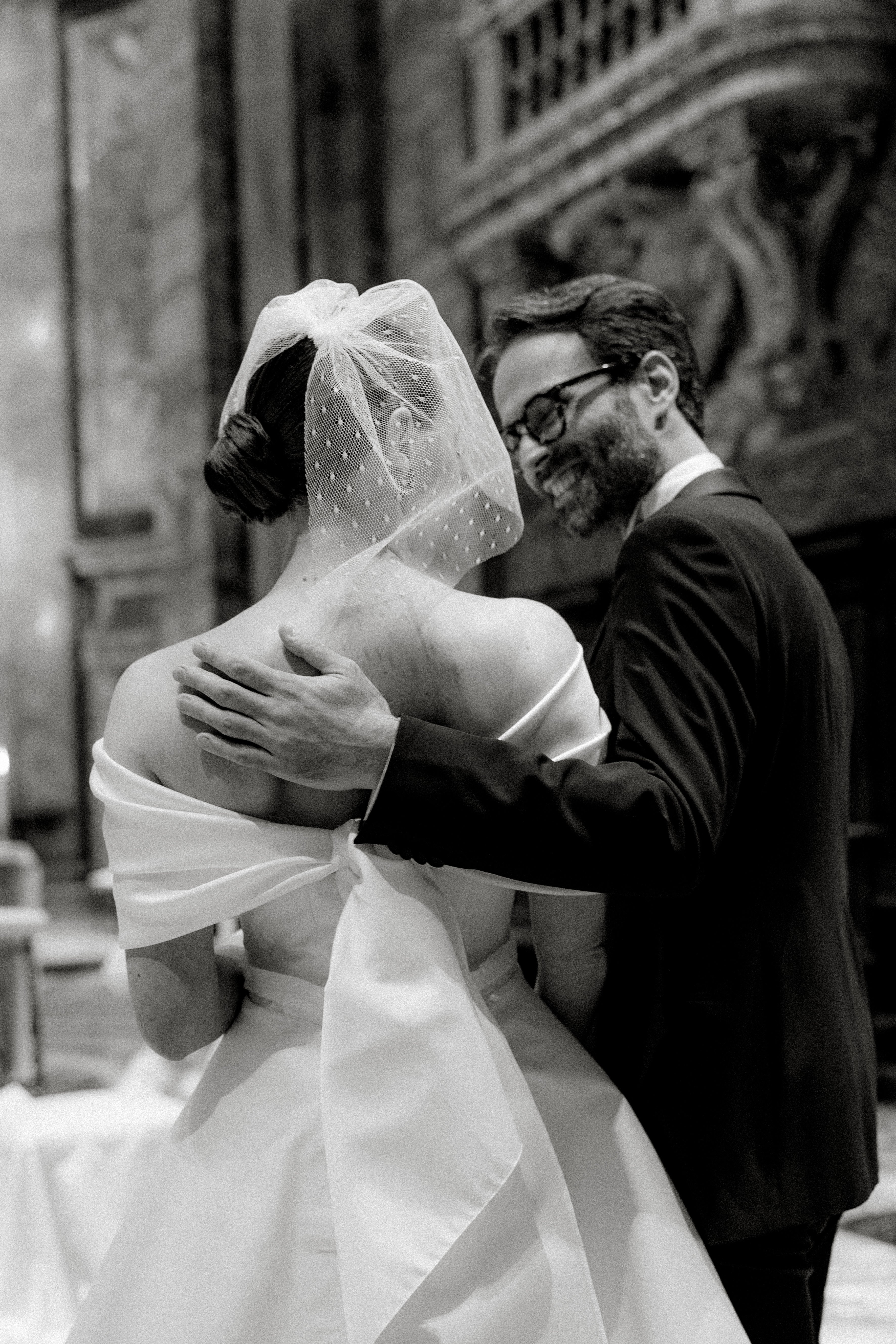 Elegant bride in a short birdcage veil and bold red lipstick, evoking retro glamour