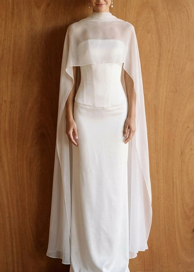 Bride wearing a sheer silk chiffon bridal cape draped over both shoulders, high funnel neckline, natural white