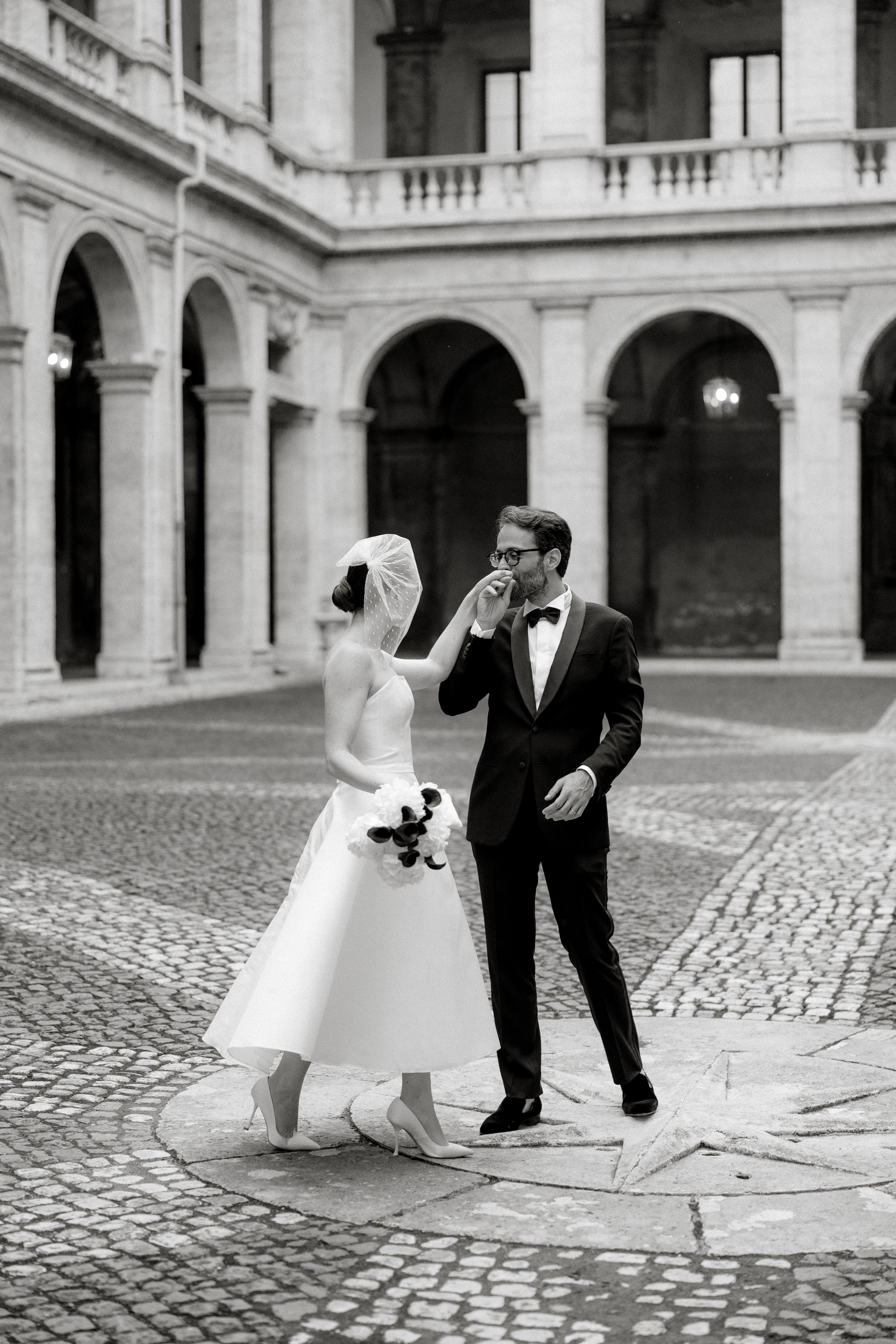 Modern bride pairing a minimalist gown with a chic birdcage veil and pearl earrings