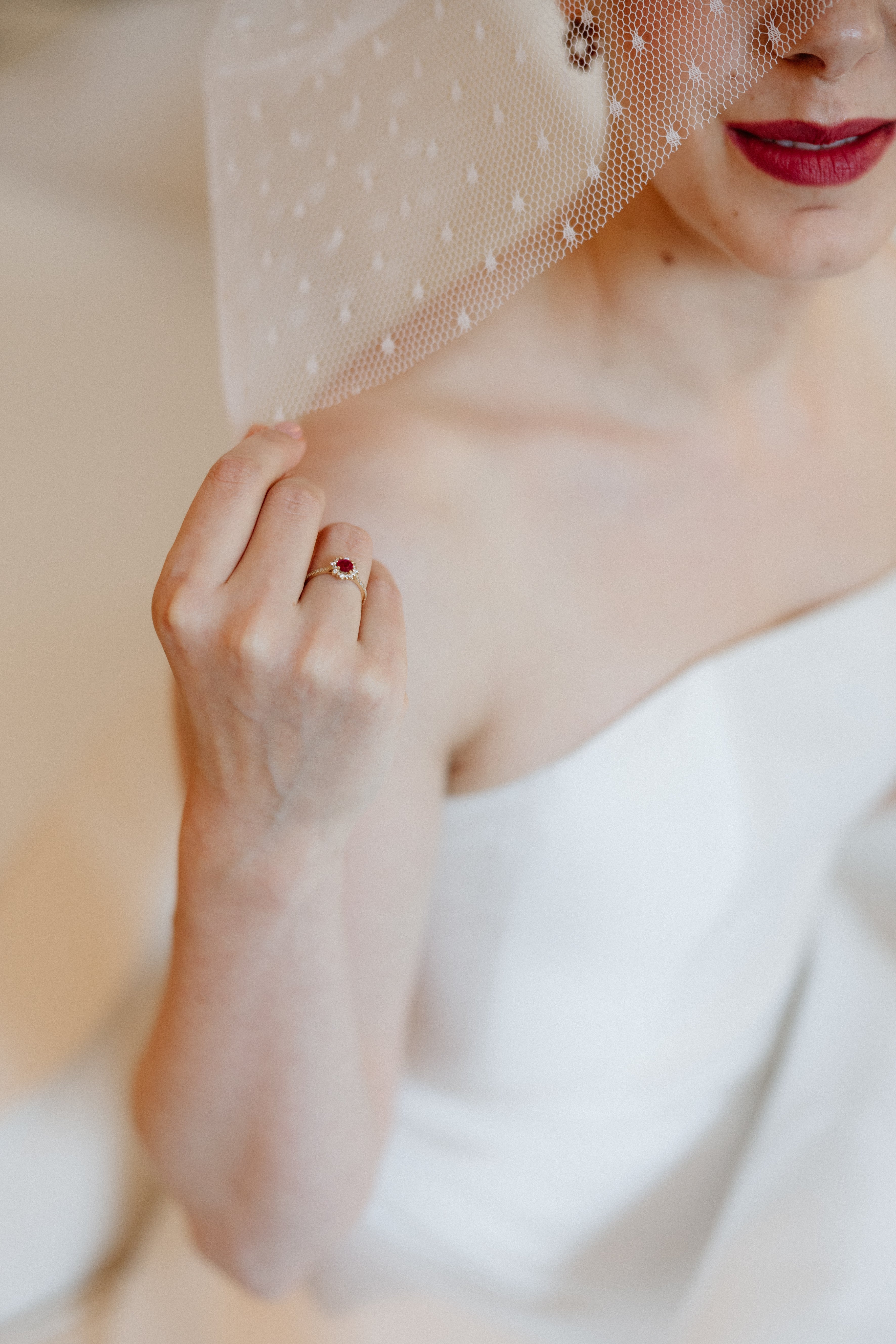Side profile of a bride with a birdcage veil tucked into a sleek low bun