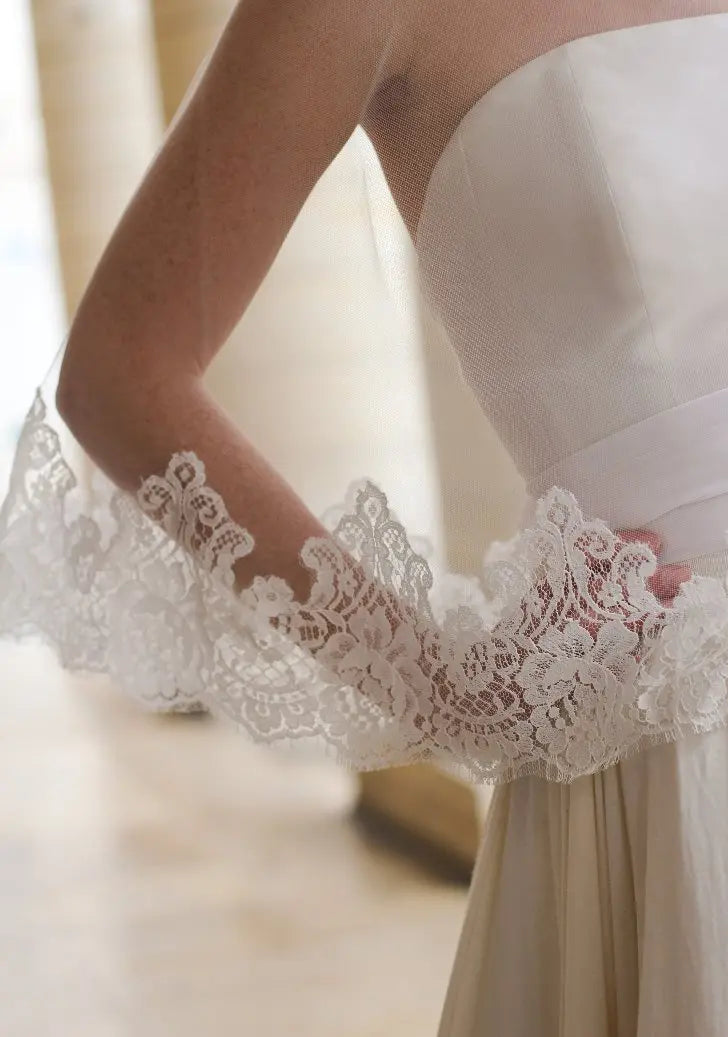 Voile de mariée ivoire avec bordure en dentelle florale, parfait pour un look romantique.