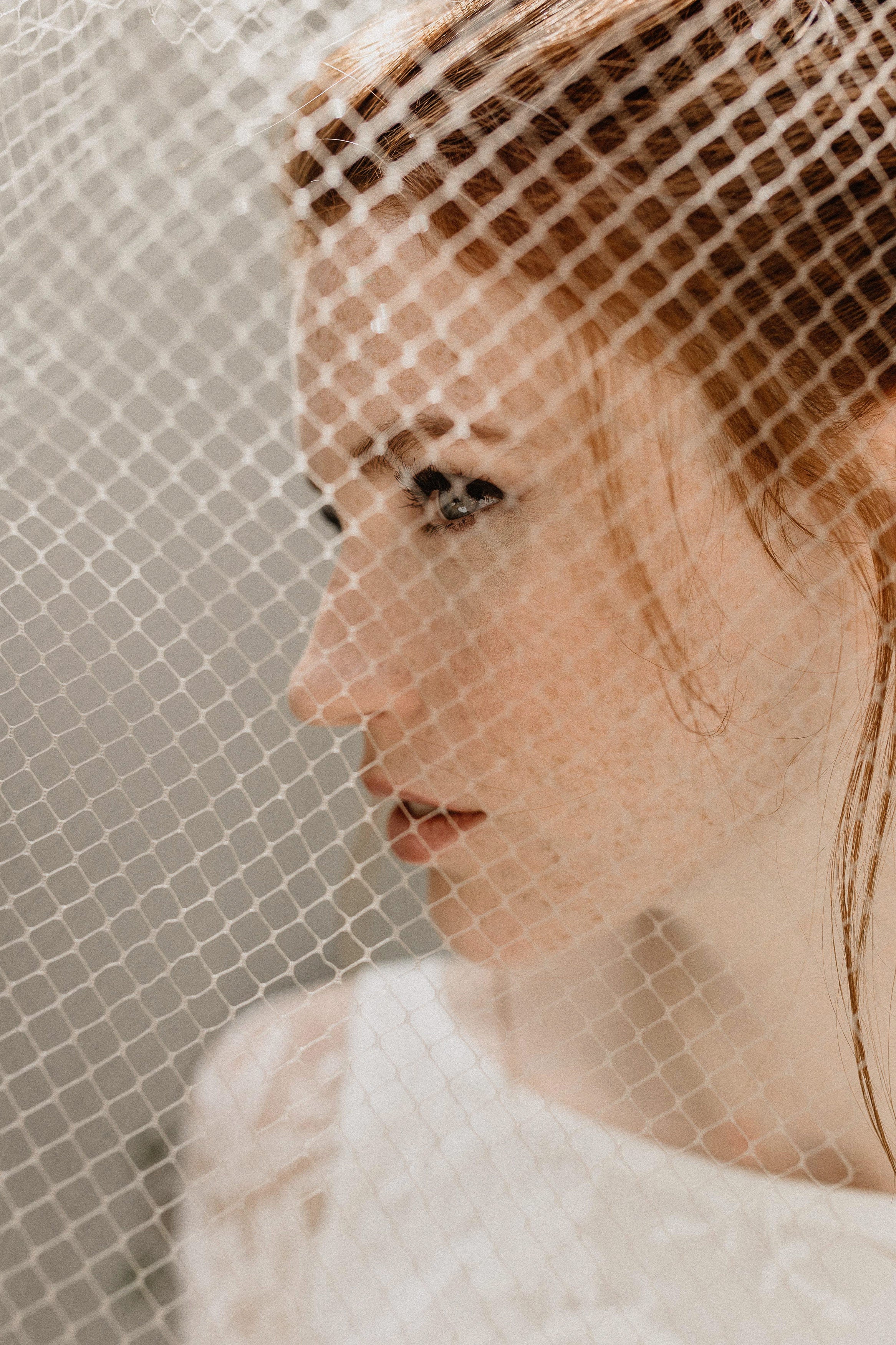 Side profile of bride with vintage-style voilette veil tucked into low bun