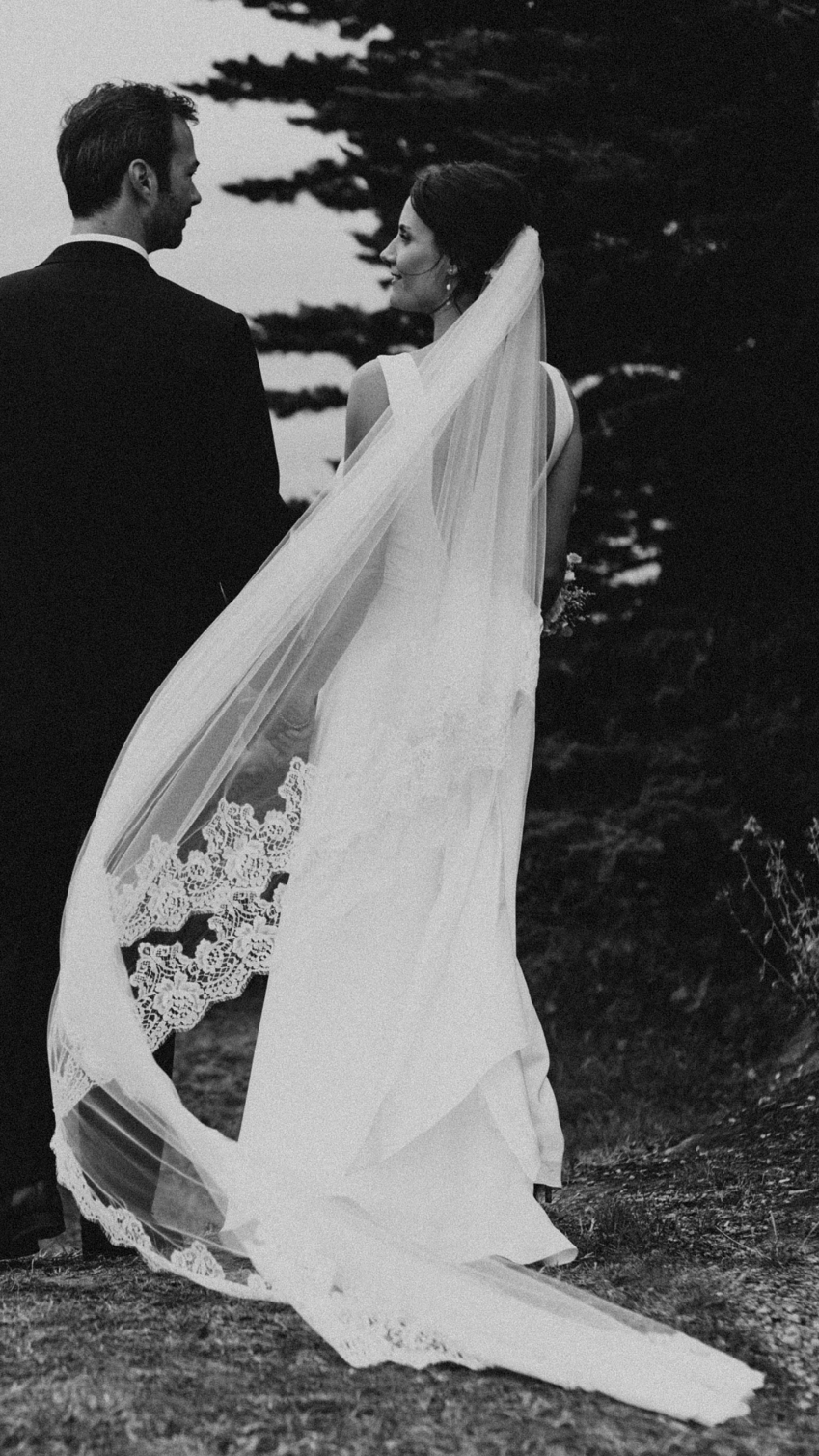 French bride wearing a lace cathedral veil blowing in the wind