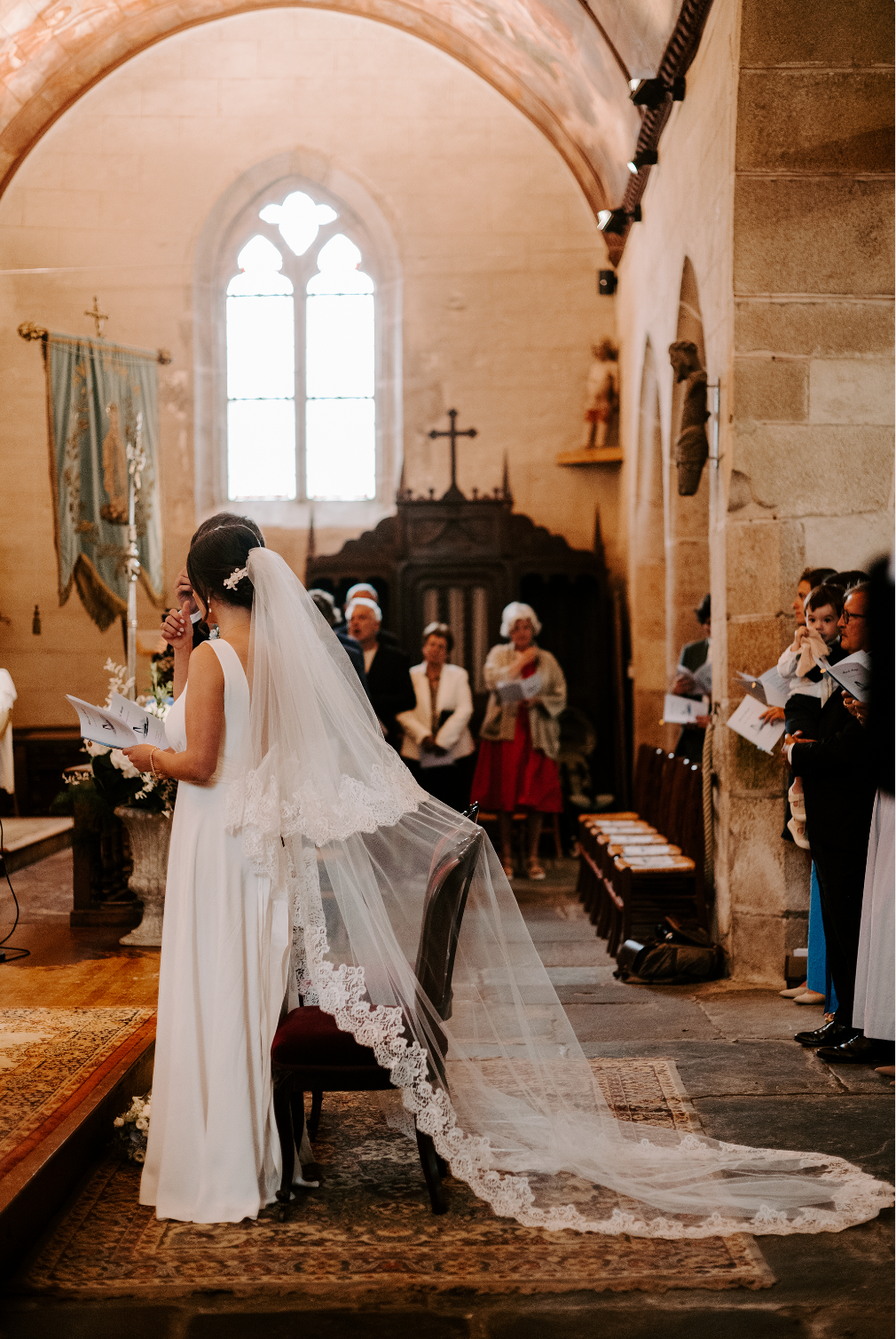 Catholic bride in church at the altar wearing a lace wedding veil