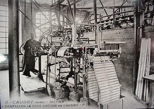 Historical lace-making machine in a factory in Caudry, France, showcasing traditional lace production methods during the early industrial era.