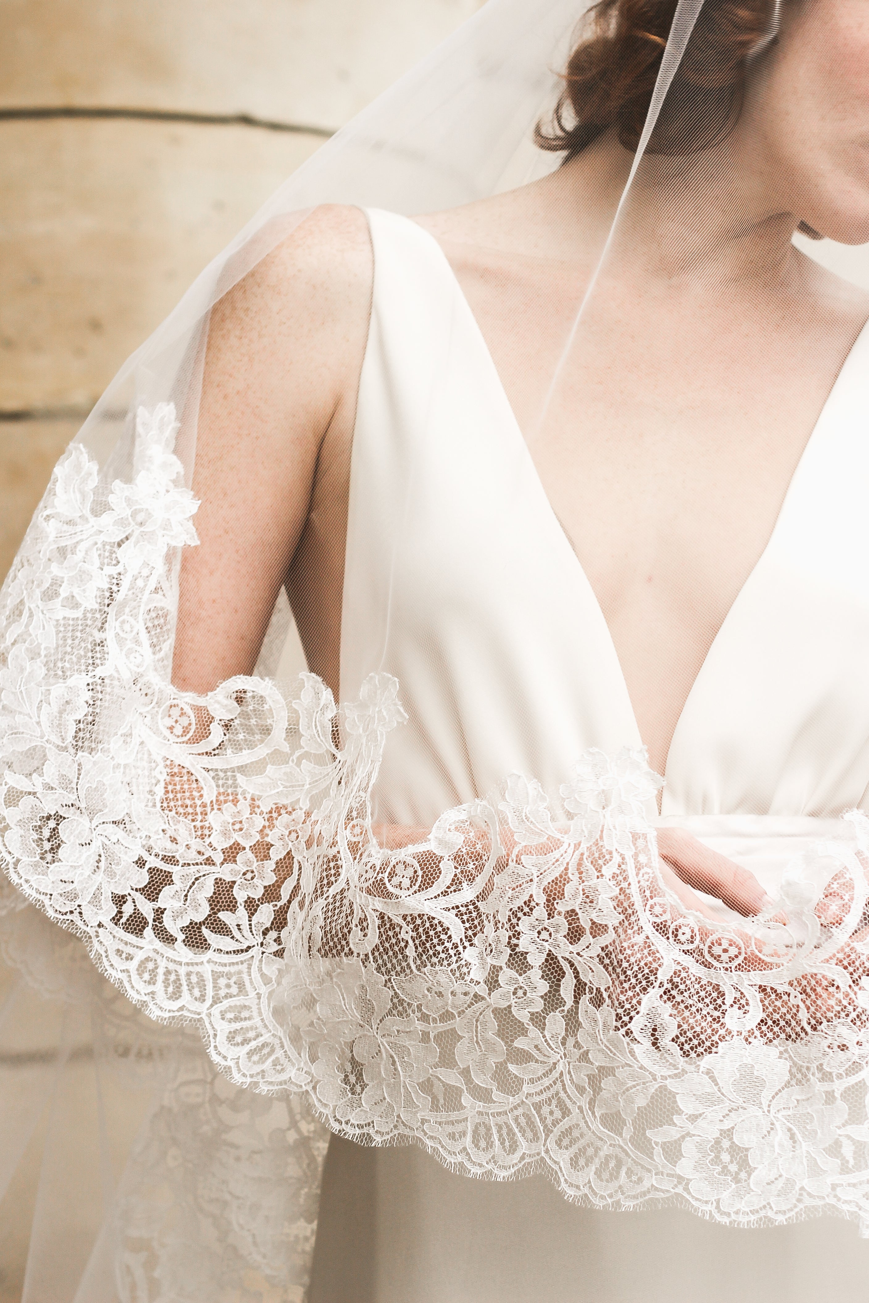 Bride wearing a beautiful lace wedding veil of cathedral length