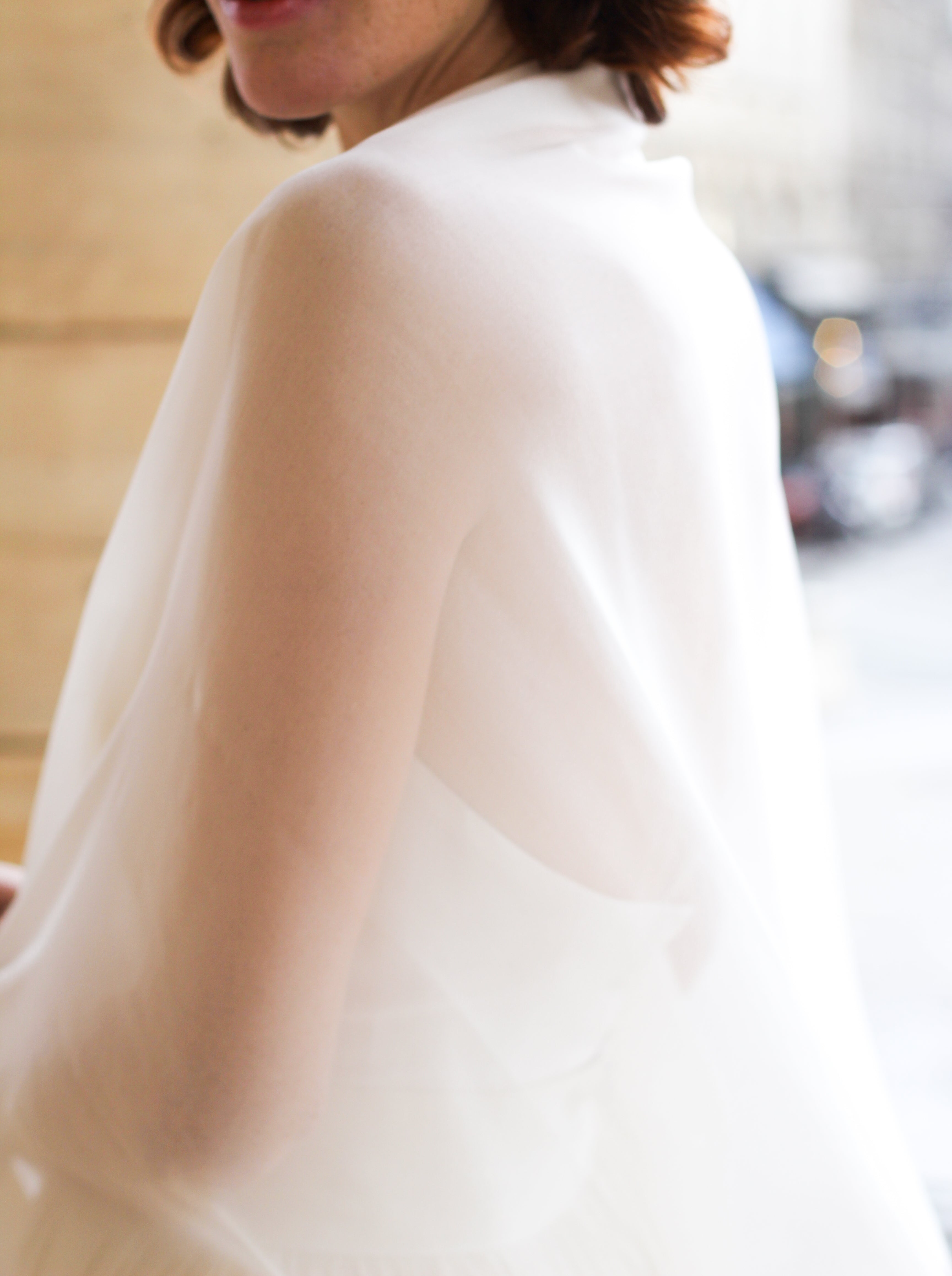 Bride wearing a natural white silk wedding shawl wrap