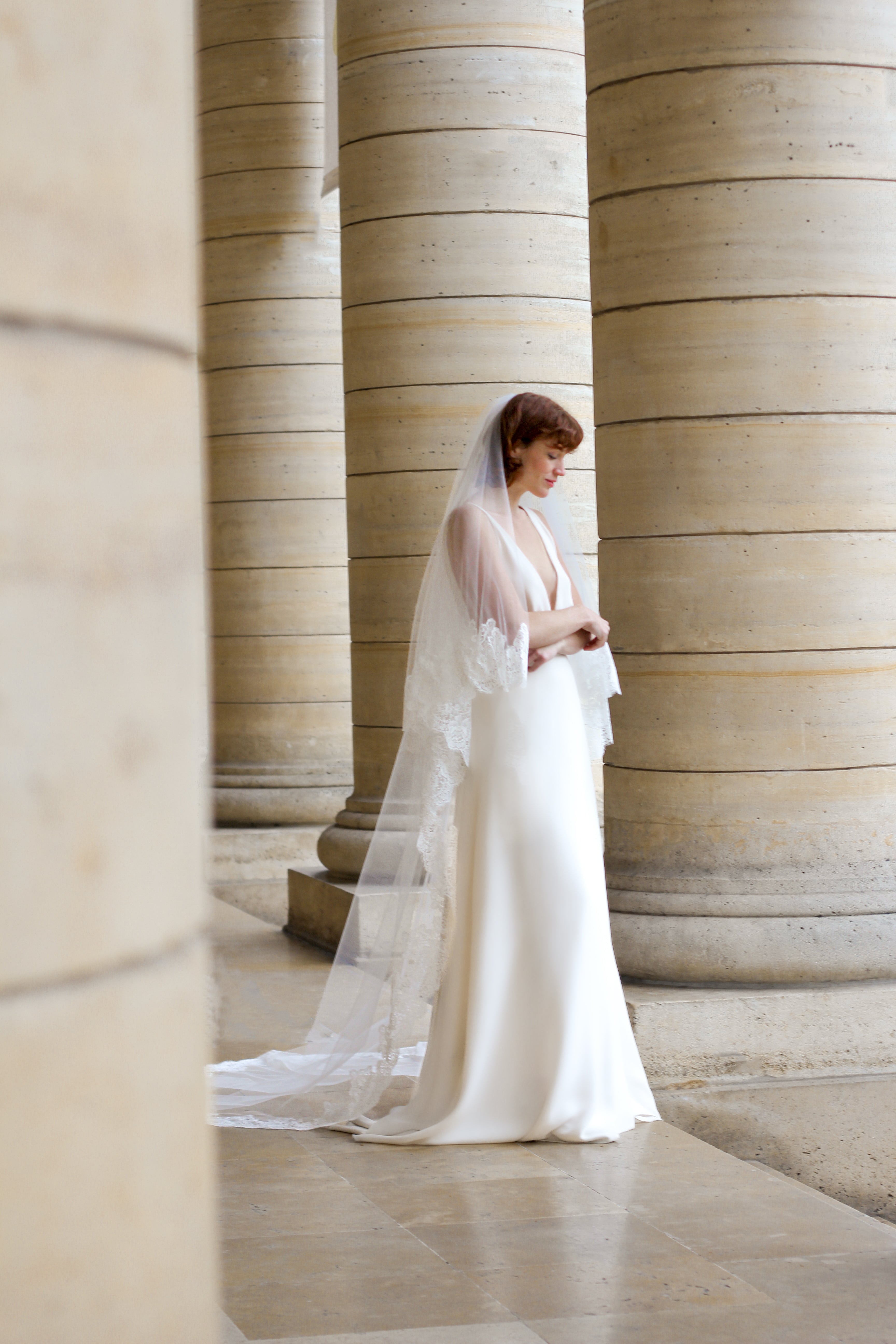 Young bride wearing a cathedral veil with floral details on the edge.